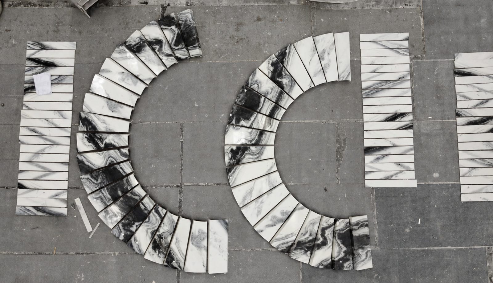 Panda White marble curved stair treads dry-laid on our factory floor before packing