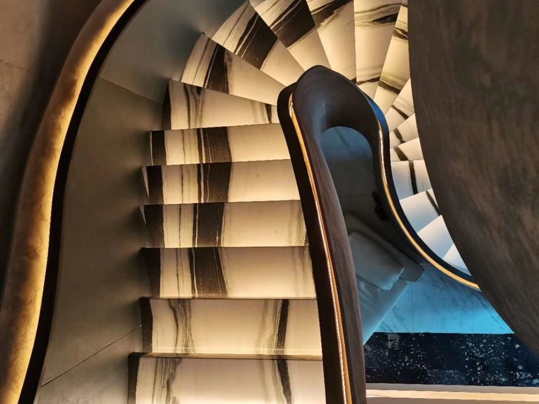 Spiral staircase with backlit Panda White marble treads